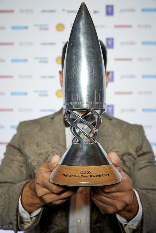 A man stands with the GCHQ project management award trophy
