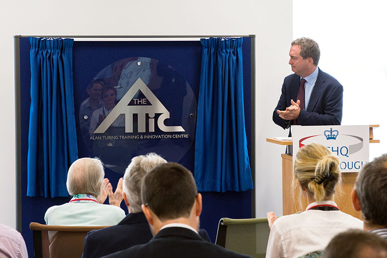 'The Attic' logo is silver on blue, and triangular