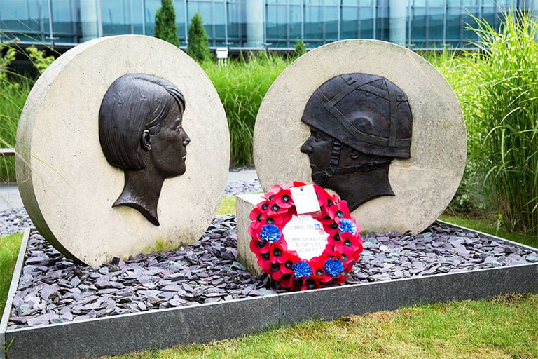 A red wreath dedicated to the fallen at the Somme on the GCHQ Memorial in the courtyard garden