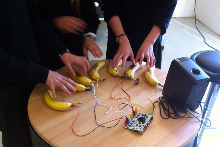 Bananas being used like piano keys.
