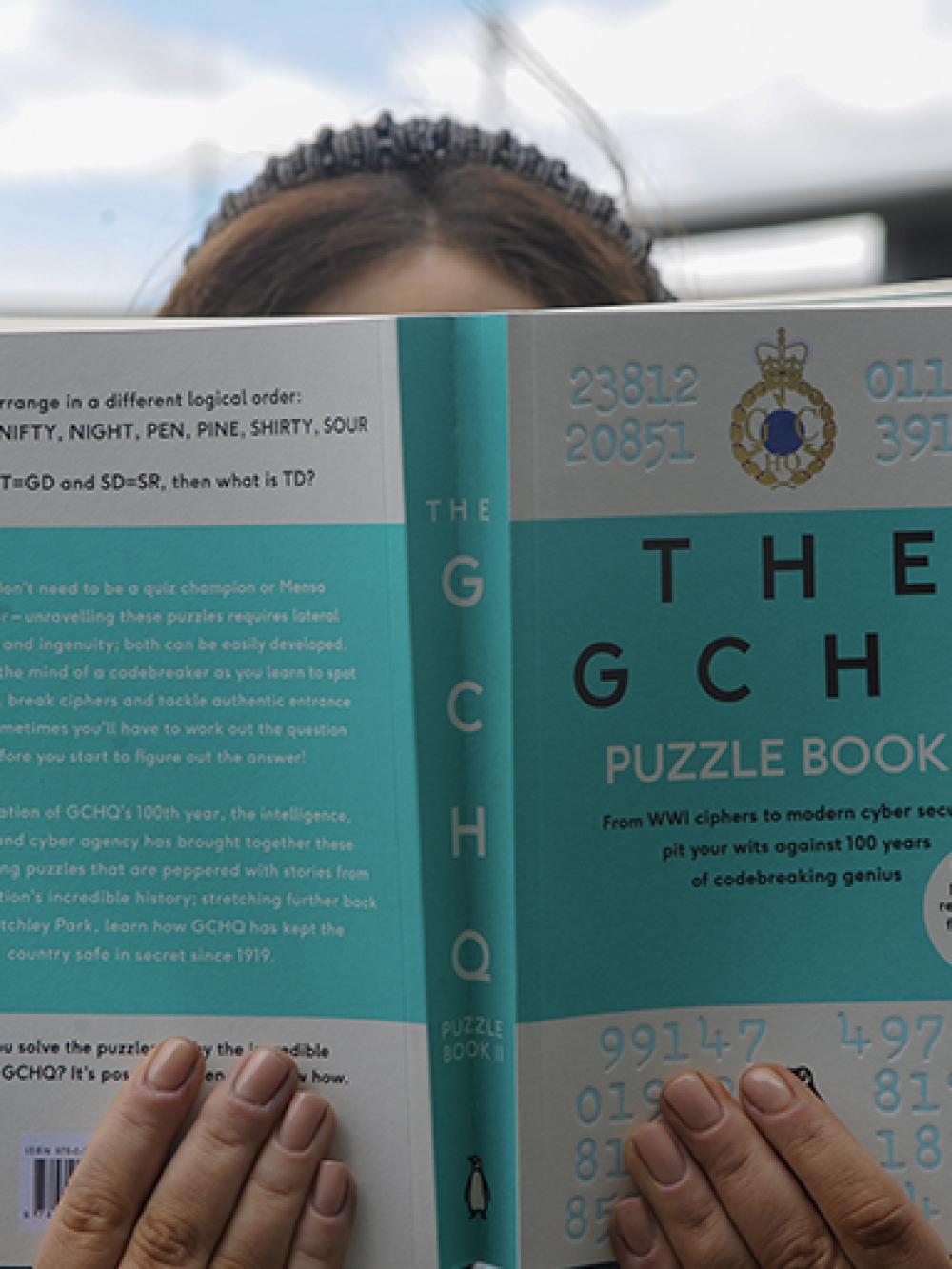 Woman holding open the GCHQ Puzzle Book 2