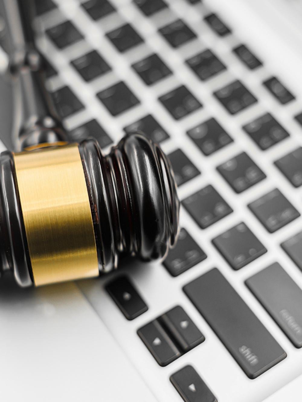 A gavel resting on a laptop keyboard