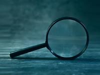 An image of a magnifying glass on a dark background
