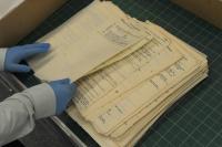 Hands sifting through notes from the GCHQ Archives