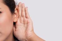 Woman cupping ear with hand