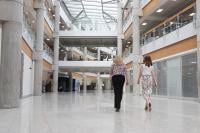 Two women, Emily and Vicky, with their backs to the camera, walking alongside each other inside GCHQ's headquarters