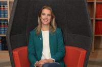 Image of Danielle George on a red sofa