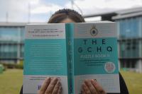 Woman holding open the GCHQ Puzzle Book 2