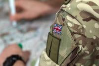 A close-up of the arm of a person in military uniform. The Union Jack is sewn onto their sleeve.