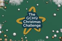 The GCHQ Christmas Challenge logo on a green background surrounded by baubles and tinsel