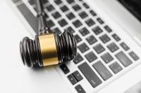 A gavel resting on a laptop keyboard