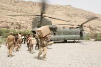 Servicemen carrying boxes from a military helicopter in Afghanistan