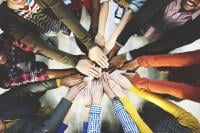 Diverse hands put in to the middle of a circle