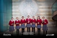Westonbirt School winners, an all-female team, holding their trophies and standing in front of the GCHQ Crest in the foyer